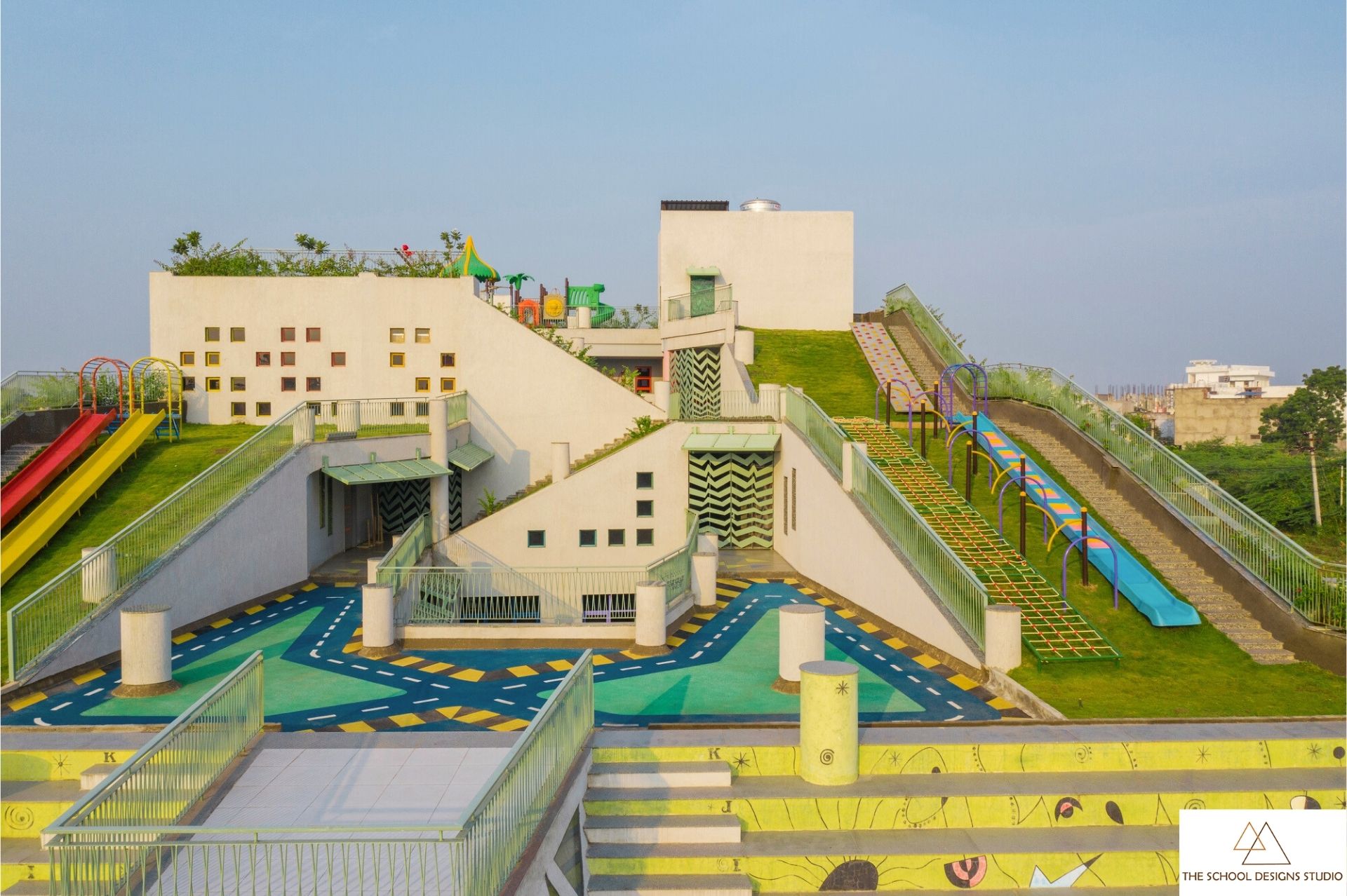 Vibrant rooftop playground at Sangam Elementary School in Bhilwara, Rajasthan, showcasing child-centric school architecture with colorful slides, green terraces, and modern design that boosts school brand value.